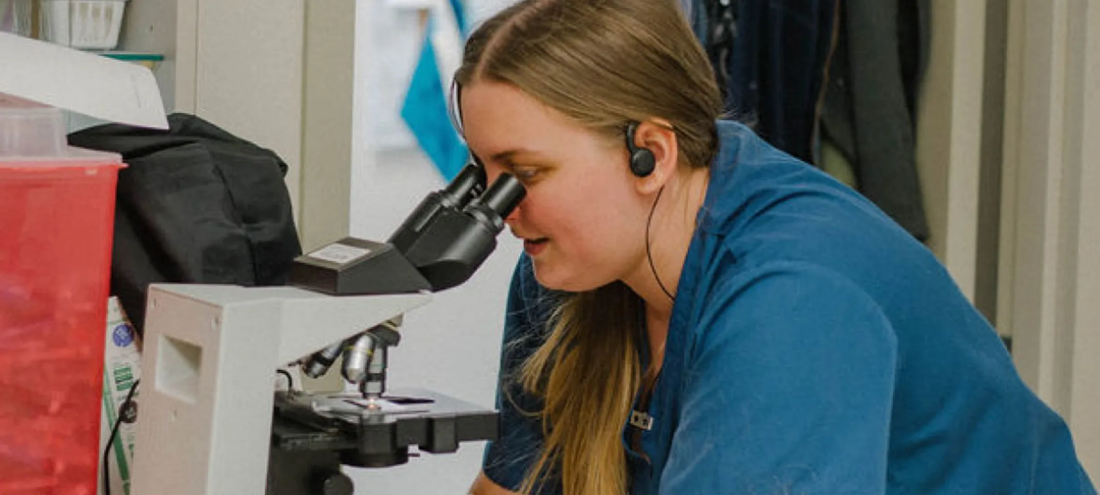 Coronado staff looking through a microscope.