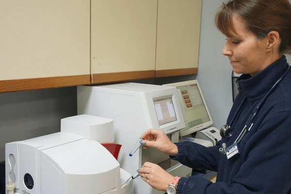 Strawbridge Animal Care's lab room 1 where there is a female staff member using one of their medical equipment.