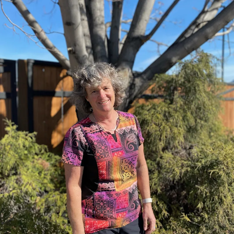 Heather smiling standing outside in front of a tree Heather smiling standing outside in front of a tree