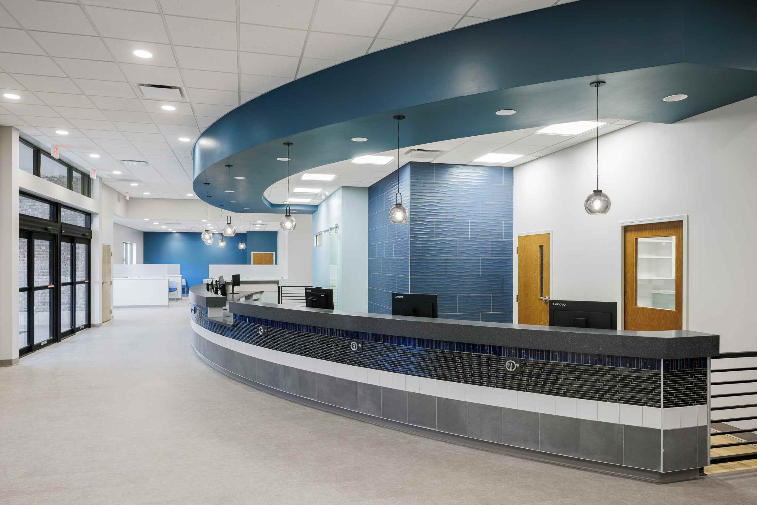 Blue and gray circle reception desk against a white wall.