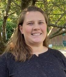 Sarah posing outside with trees in the background