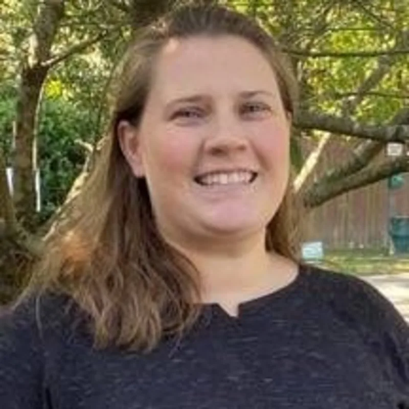 Sarah posing outside with trees in the background Sarah posing outside with trees in the background