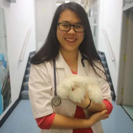 A doctor posing with a white rabbit