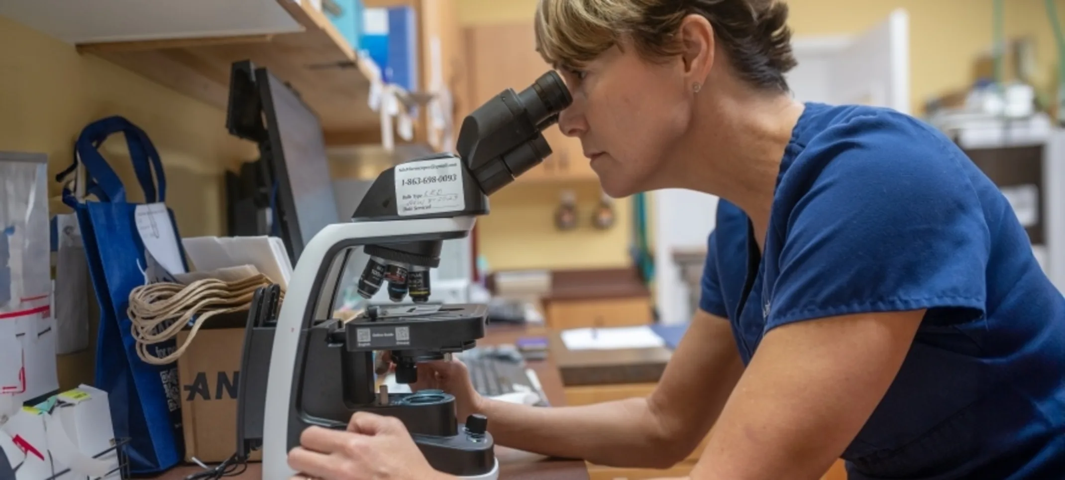 Woman looking through microscope Woman looking through microscope