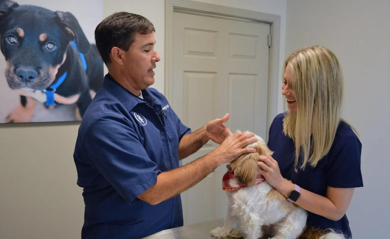 Dr. Story and a veterinary staff member examining a dog Dr. Story and a veterinary staff member examining a dog