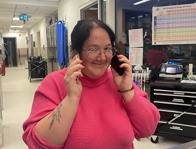 Staff member holding phones Staff member holding phones
