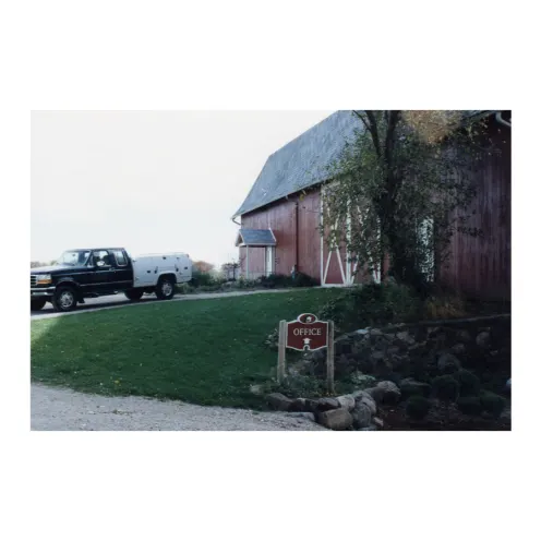 An older photo of WECH's red barn with a Ford pickup truck outside