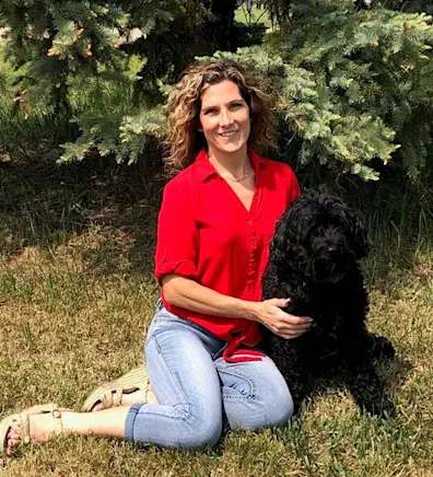 Kari sitting on the grass with a dog Kari sitting on the grass with a dog