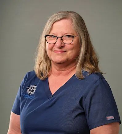 Sue's staff photo from Lifetime Animal Care Center where she is holding a puppy with a graduating cap on its head. Sue's staff photo from Lifetime Animal Care Center where she is holding a puppy with a graduating cap on its head.