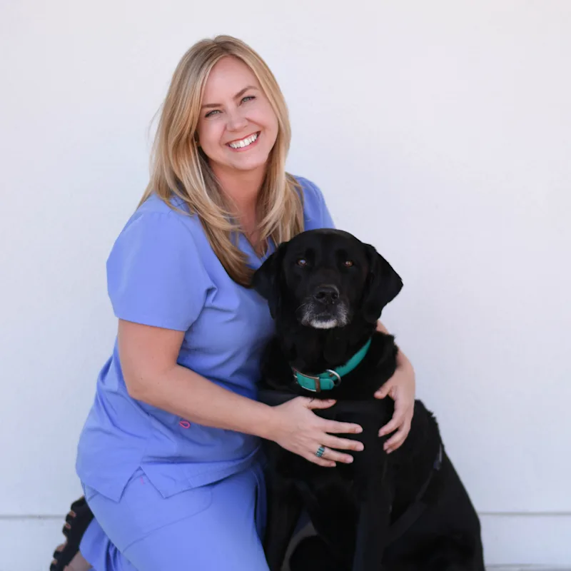 Morgan Domangue smiling and posing with a black dog Morgan Domangue smiling and posing with a black dog