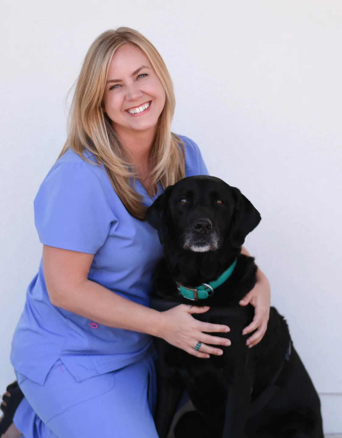 Morgan Domangue smiling and posing with a black dog Morgan Domangue smiling and posing with a black dog