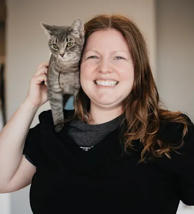 Alissa Wakeley dressed in black with a gray kitten on her shoulder