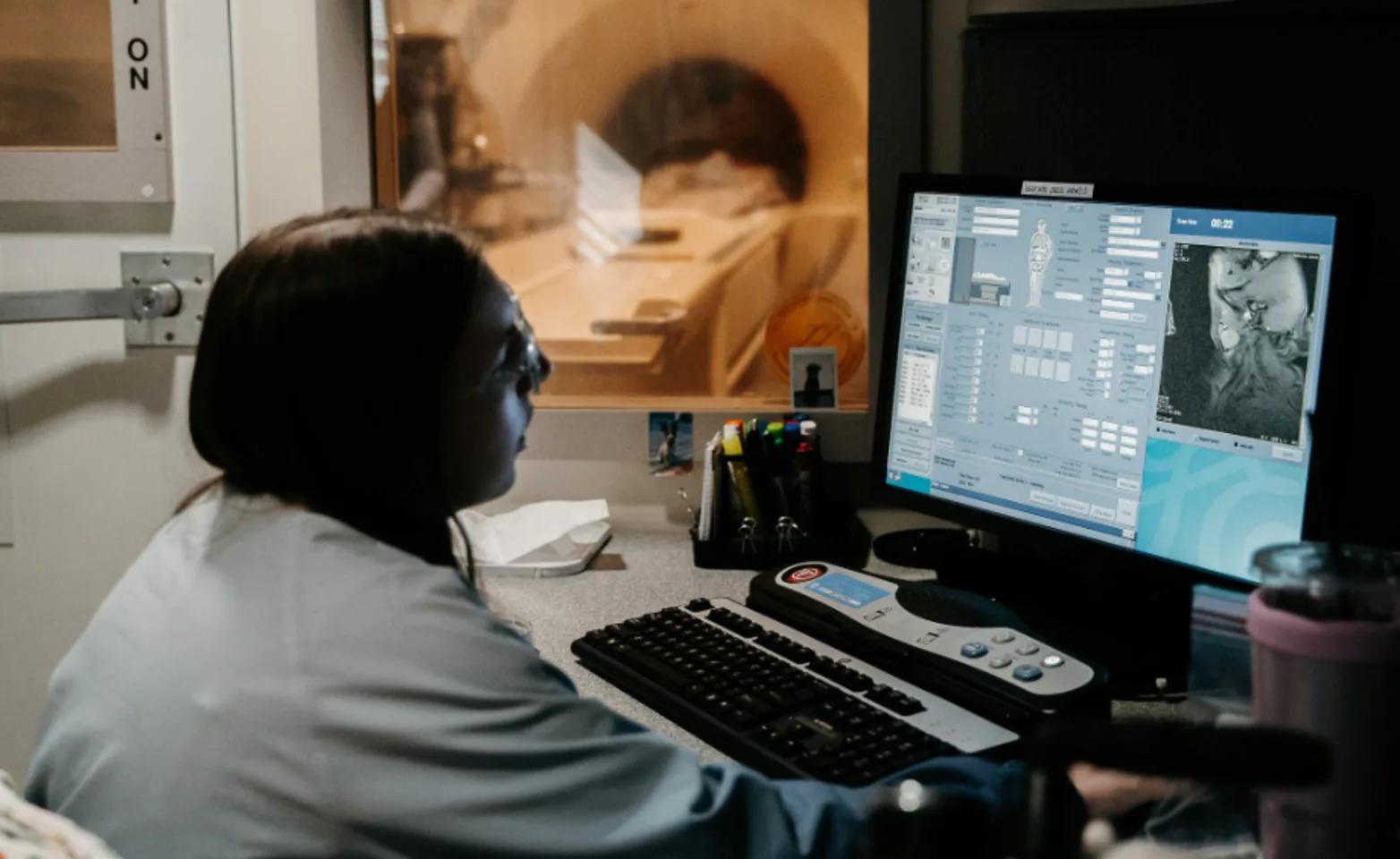 Staff member looking at neurology scans Staff member looking at neurology scans
