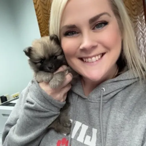 Staff Member Smiling with Puppy Staff Member Smiling with Puppy