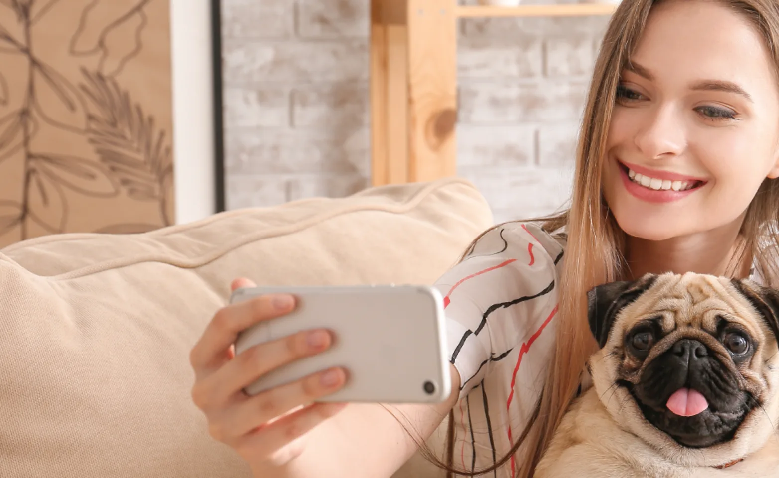 Women holding a phone pointing at dog Women holding a phone pointing at dog