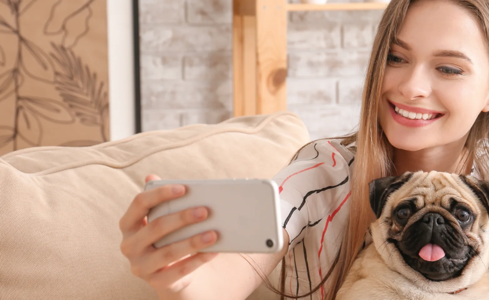 Women holding a phone pointing at dog