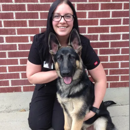 Megan Thompson knealing next to german shepherd