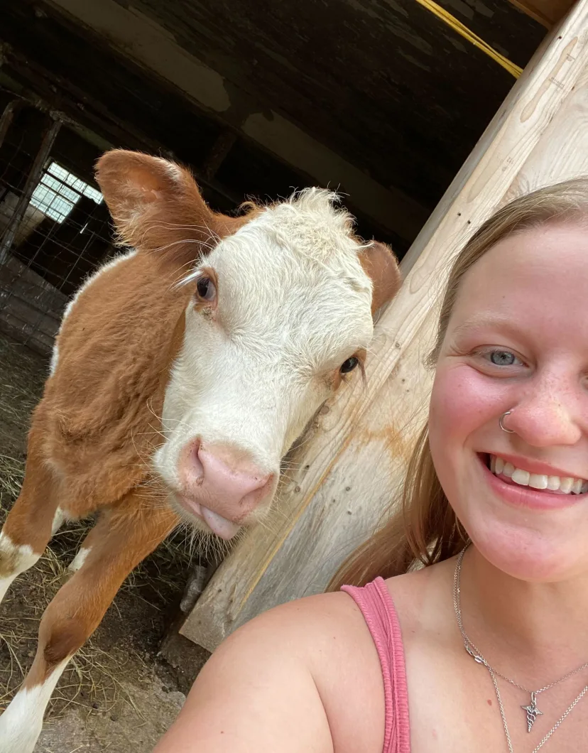 Ella with a brown and white cow