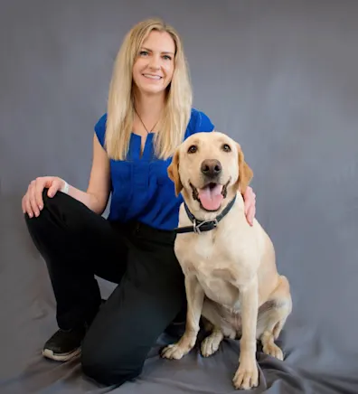 Dr. Katie Chiles sitting with a dog Dr. Katie Chiles sitting with a dog