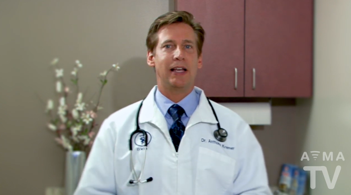 Man in white lab coat speaking to camera