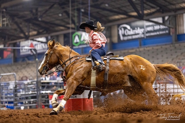 Woman riding a brown horse.