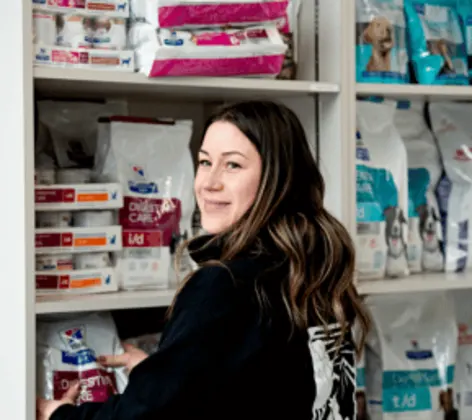 A staff member in front of pet food A staff member in front of pet food