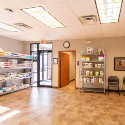 A photo of The welcoming lobby and waiting area at Dunes Animal Hospital, which has shelves stocked with animal food.