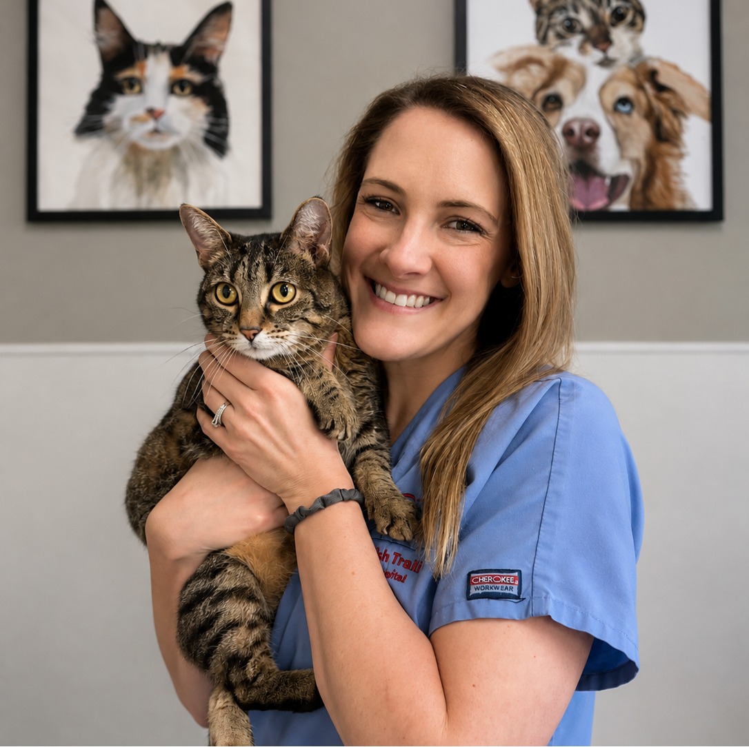 Lindsay C.'s staff photo from Spanish Trail Animal Hospital where she is outside in the front yard holding a fluffy brown dog in her arms.