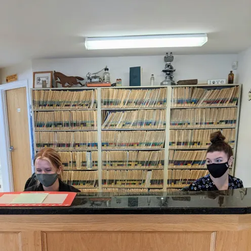 Two staff members working at the front desk at Henniker Veterinary Hospital