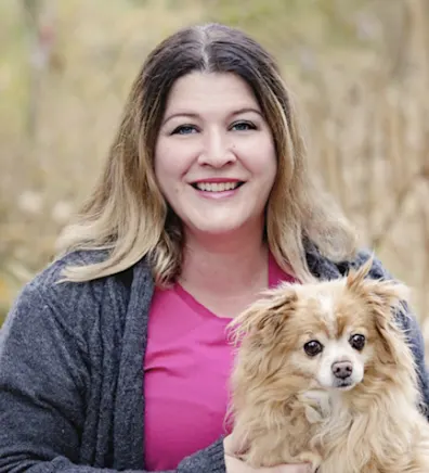 Anne holding a golden fluffy dog