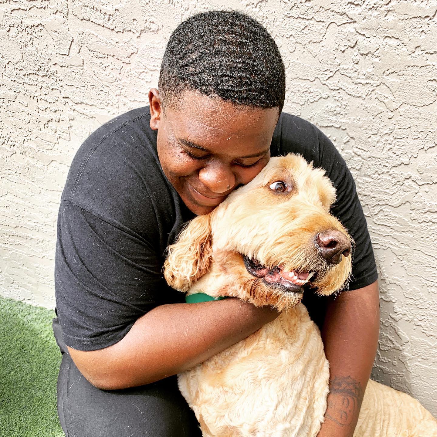 A posh pet staff hugging a big dog