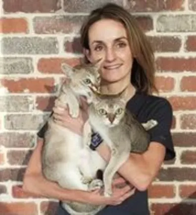 Hillary MacConaghy holding two grey cats