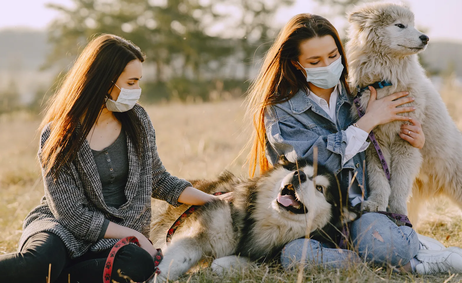 2 girls with mask on with their two dogs