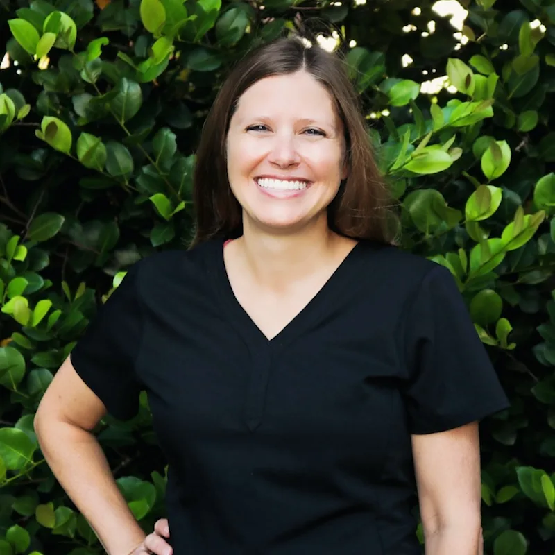 Dr. Kelly smiling with a two cute dogs beside her Dr. Kelly smiling with a two cute dogs beside her
