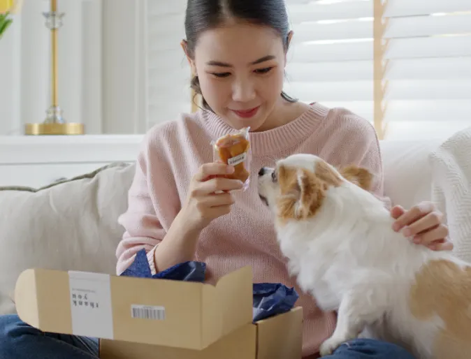 Girl Giving Dog a Treat From Package Girl Giving Dog a Treat From Package