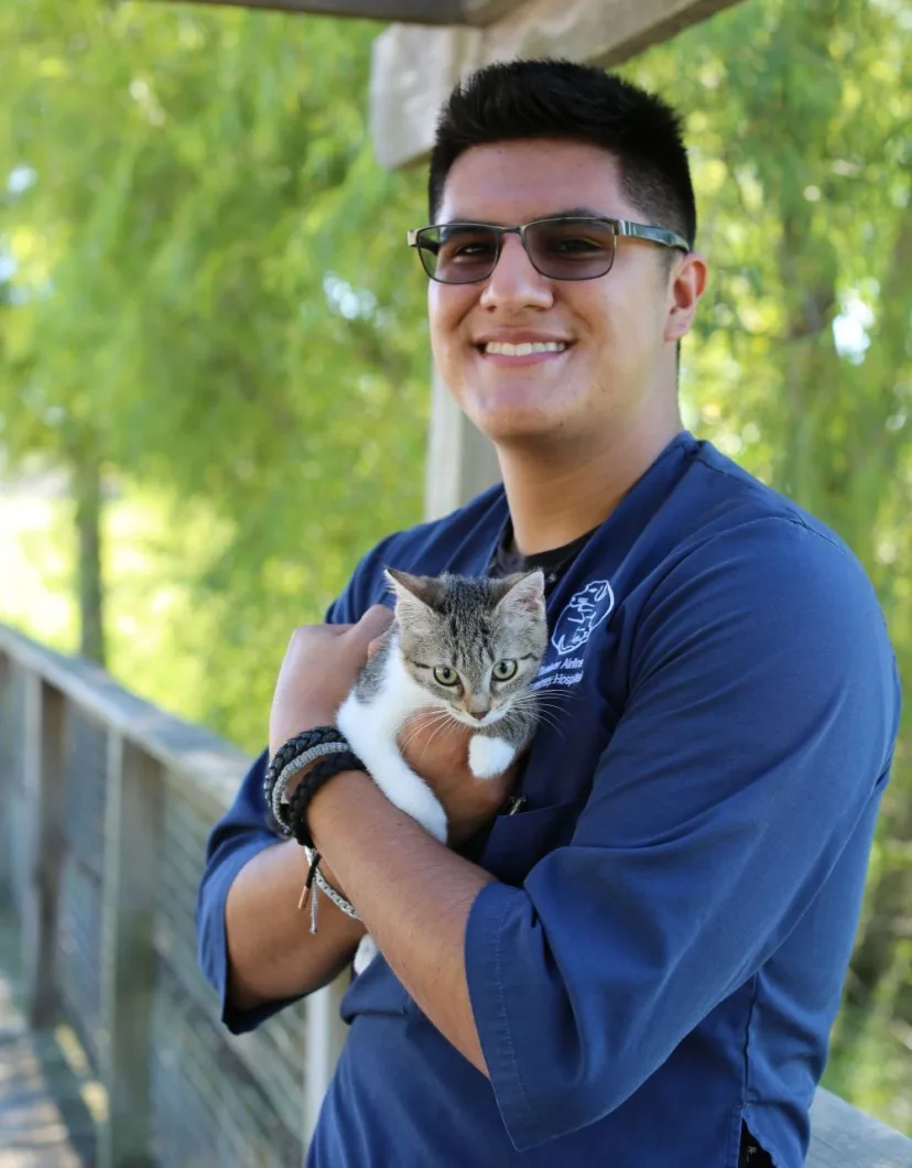 Favian holding a small kitten named Lannie