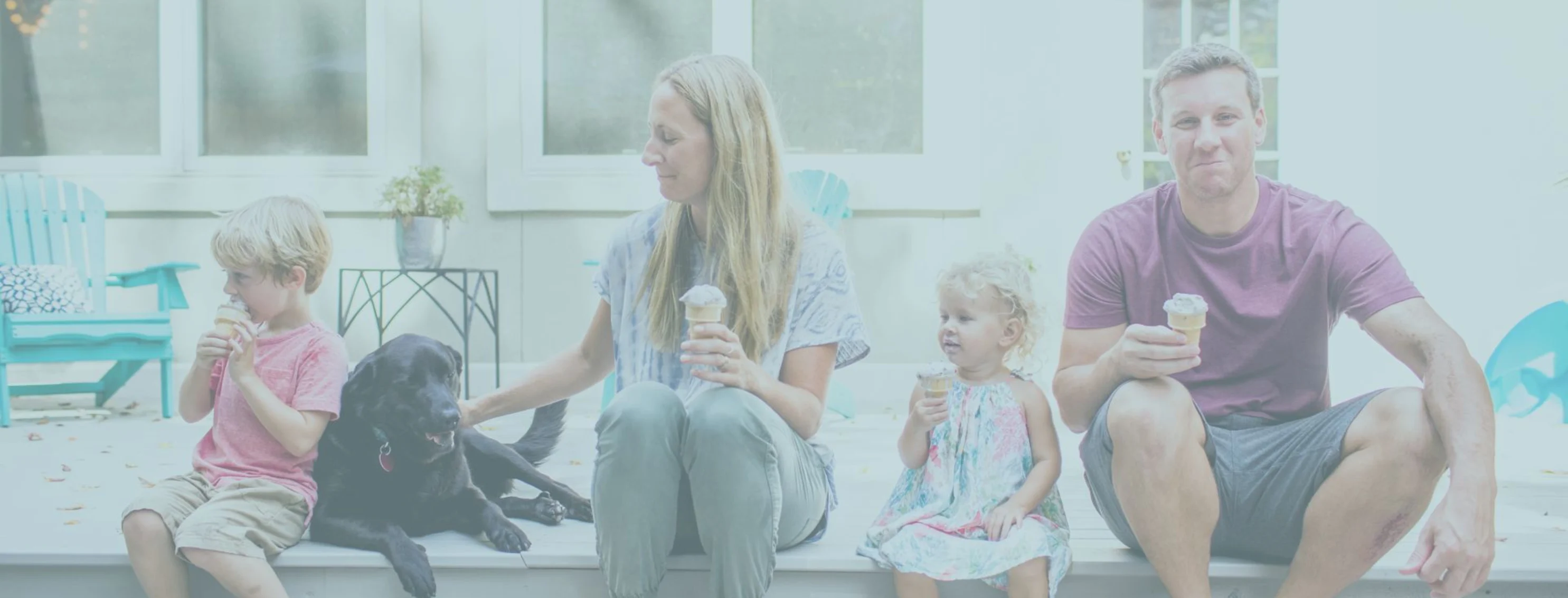 Family sitting on a curb with their dog eating ice cream Family sitting on a curb with their dog eating ice cream