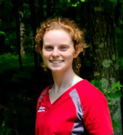 Elizabeth smiling standing outside in front of trees Elizabeth smiling standing outside in front of trees
