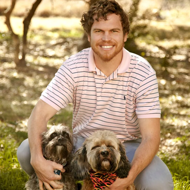 Dr. Shuman in field with two small dogs Dr. Shuman in field with two small dogs