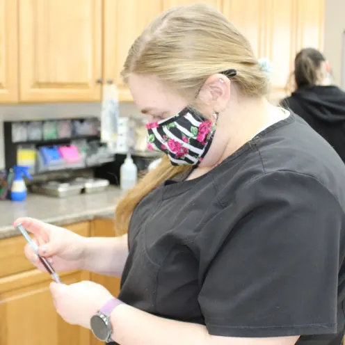 Side view of a Hunter Animal Hospital staff member inspecting a needle