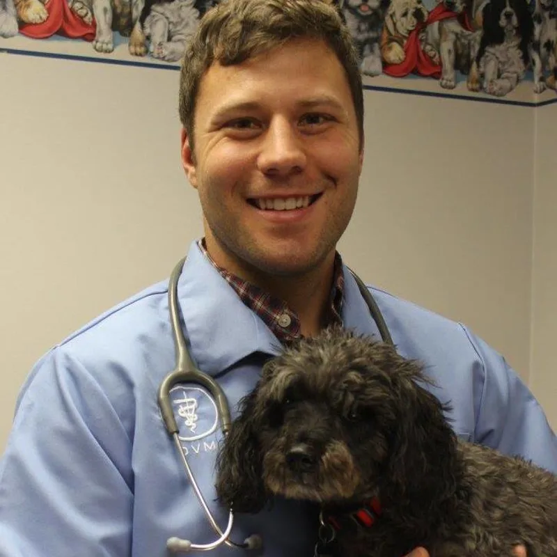 Dr. Kyle Krish, DVM holding a black dog Dr. Kyle Krish, DVM holding a black dog