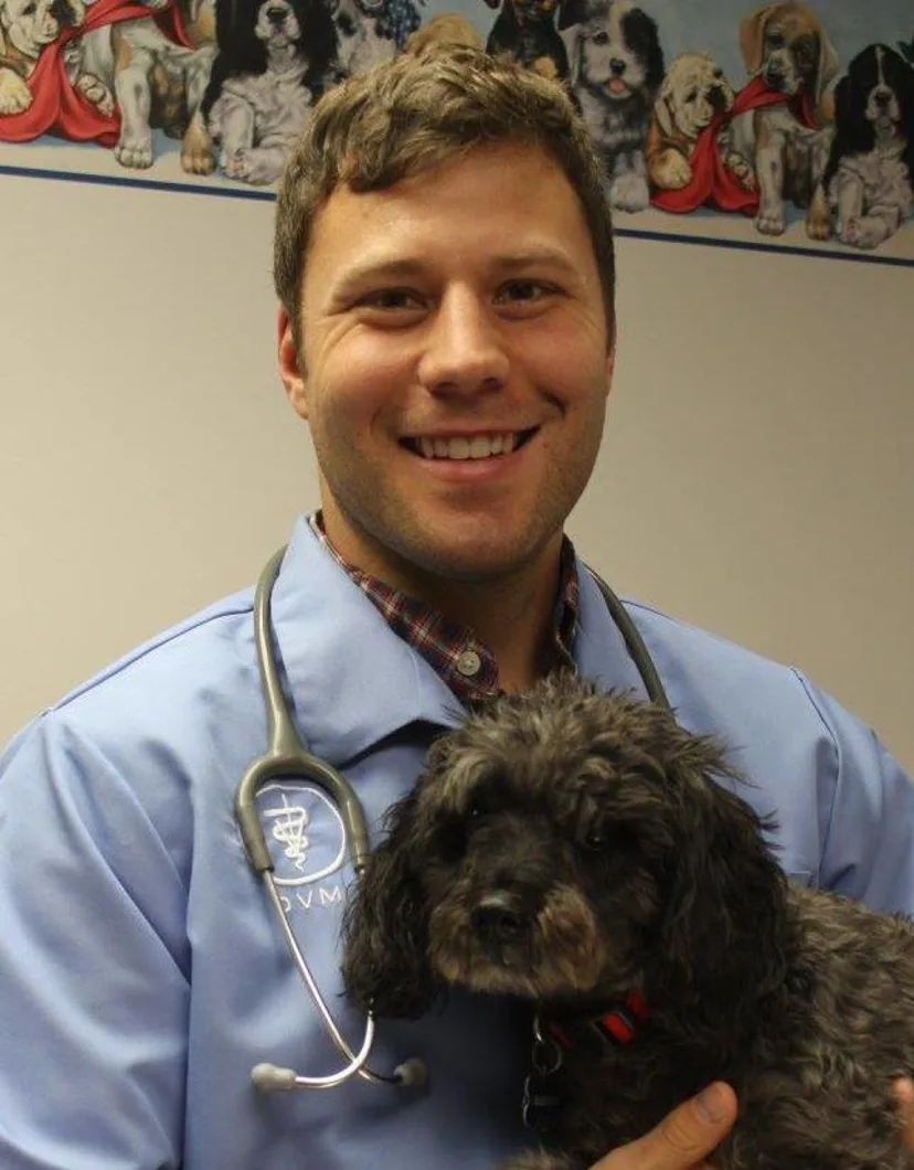 Dr. Kyle Krish, DVM holding a black dog