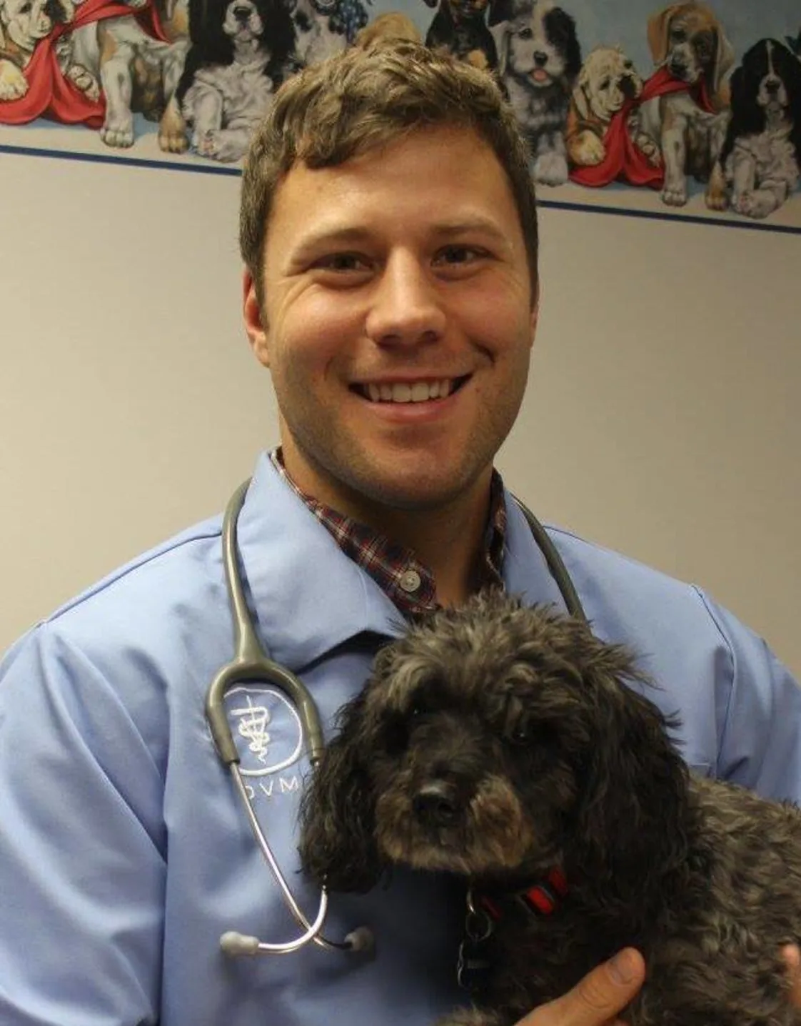 Dr. Kyle Krish, DVM holding a black dog Dr. Kyle Krish, DVM holding a black dog