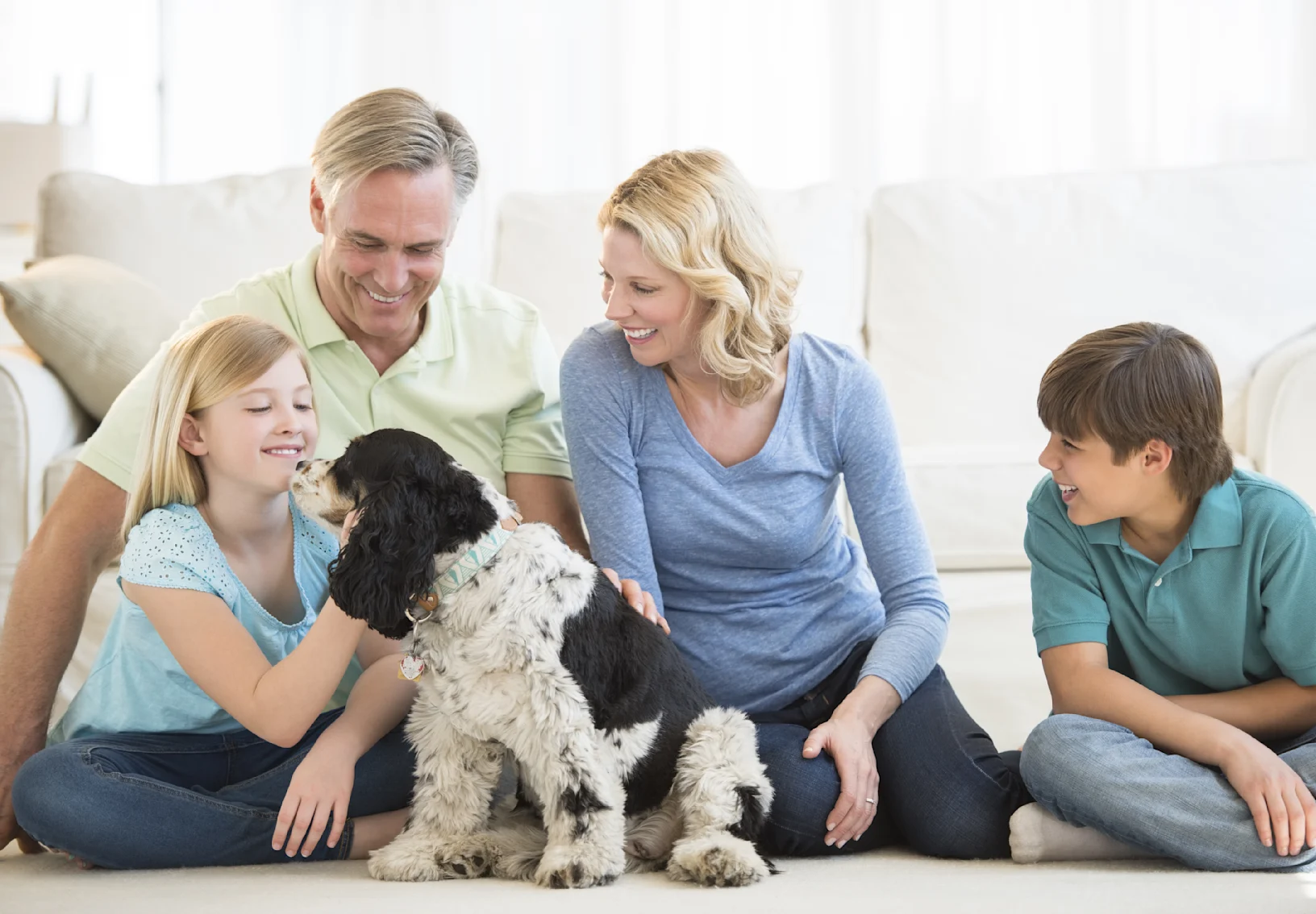 family and dog sitting in living room