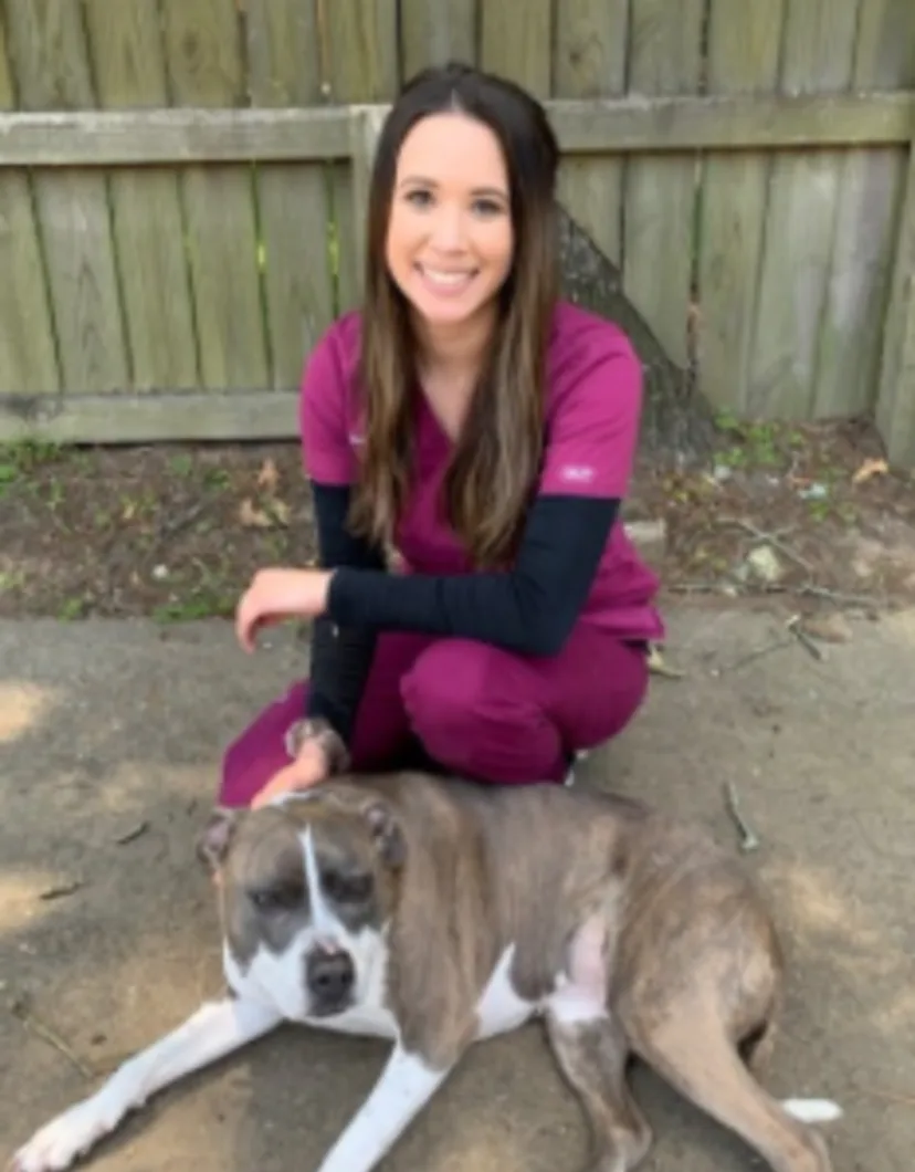 Katie Martinez sitting down with a brown dog