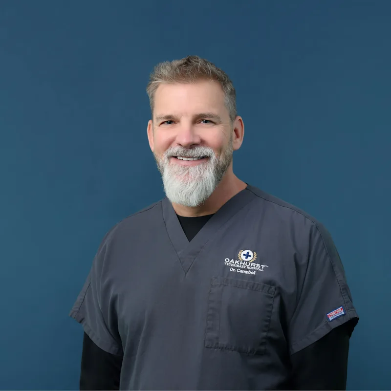 Dr. Christopher Campbell posing with a small puppy Dr. Christopher Campbell posing with a small puppy