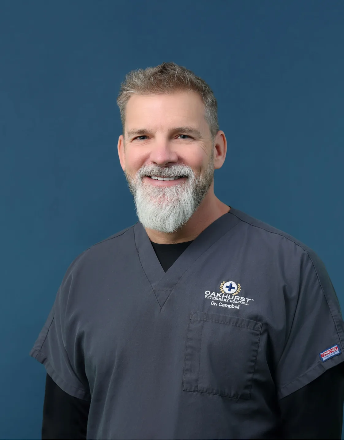 Dr. Christopher Campbell posing with a small puppy Dr. Christopher Campbell posing with a small puppy