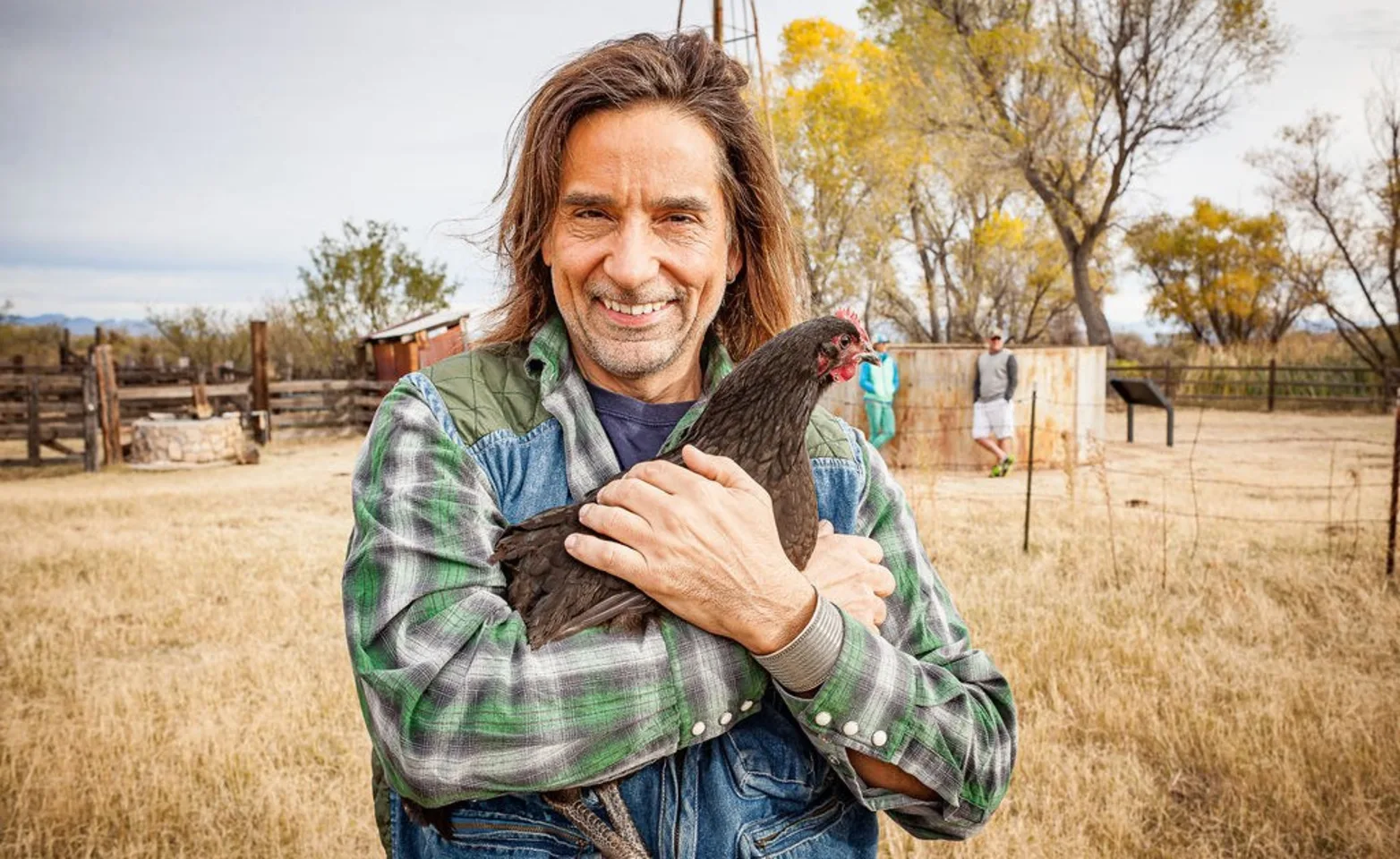Man in plaid hugging a chicken. Man in plaid hugging a chicken.