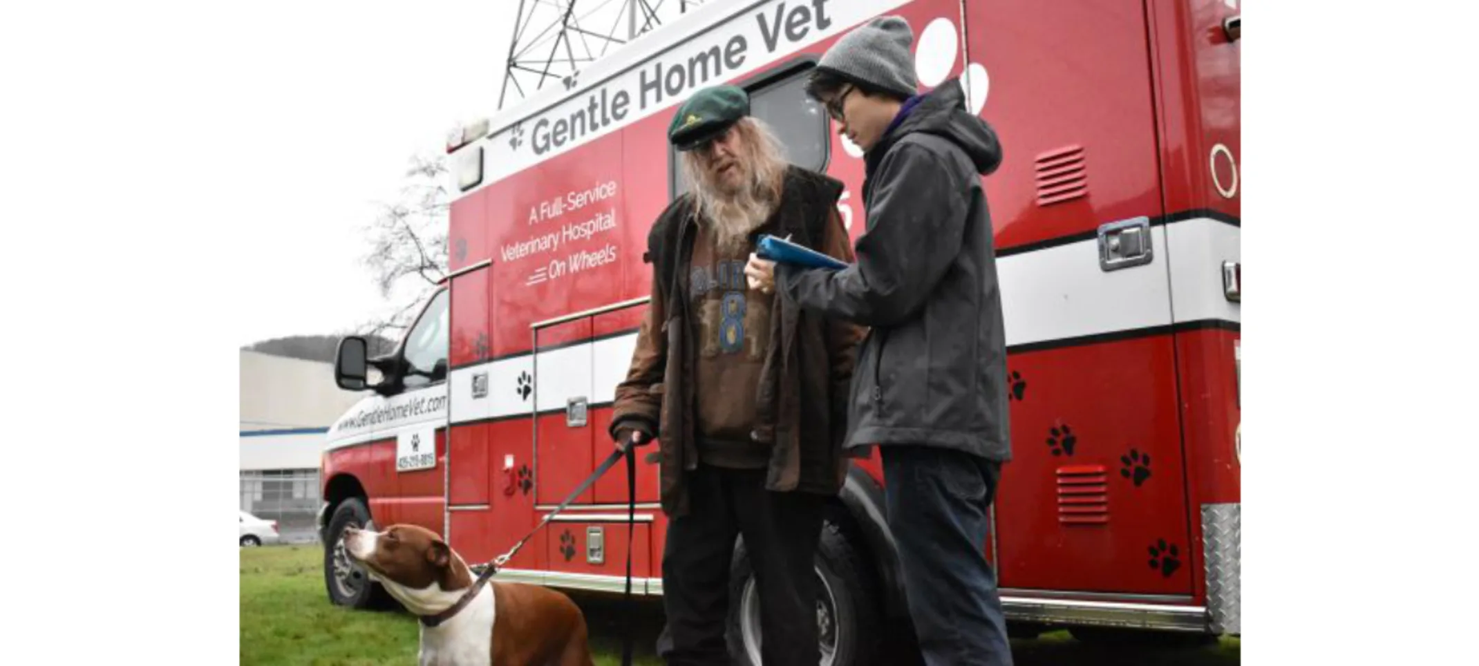 Red Gentle Home Vet truck and 2 men and a dog.