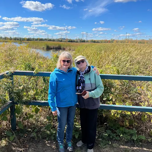 Sandra McBride smiling in nature with a friend. Sandra McBride smiling in nature with a friend.